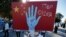 FILE - A protester from the Uighur community living in Turkey holds an anti-China placard during a protest in Istanbul, Oct. 1, 2020, against what they allege is oppression by the Chinese government to Muslim Uighurs in far-western Xinjiang province.