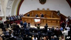 Members of the diplomatic corps, left , listen as lawmakers applaud during a session of Venezuela's National Assembly in Caracas, Aug. 19, 2017. Venezuela's pro-government constitutional assembly took over the powers of the opposition-led congress Friday.