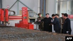 Arhiva - Severnokorejski lider Kim Džong Un, u centru, tokom posete fabrici "16. mart" na fotografiji koju je objavila državna novinska agencija Severne Koreje KCNA, 4. novembra 2019.