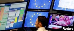 FILE - A shares trader checks his trading systems at the start of the trading session the day after the Brexit deal vote of the British parliament at the stock exchange in Frankfurt, Germany, Jan. 16, 2019.