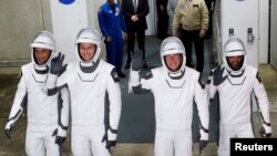 NASA astronauts Stephen Bowen and Warren "Woody" Hoburg, the United Arab Emirates' Sultan Al-Neyadi and Russian cosmonaut Andrey Fedyaev gesture ahead of NASA's planned SpaceX Crew-6 mission launch from the Kennedy Space Center in Cape Canaveral, Florida, Feb. 26, 2023. The launch was then postponed.