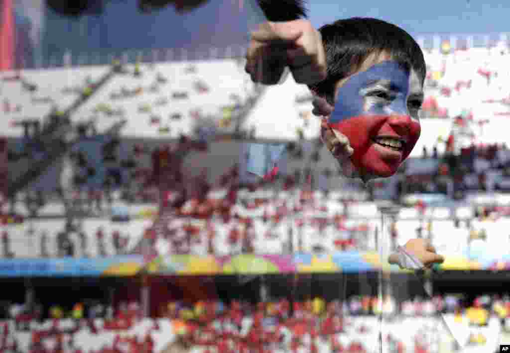 Seorang anak laki-laki pendukung Chile menunggu pertandingan timnya melawan Belanda di stadion Sao Paulo, Brazil.