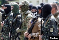 FILE - Members of the "Donbas Battalion" take part in a swearing in ceremony near Kyiv, June 23, 2014.