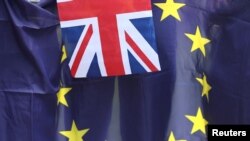 FILE - A British Union flag flies in front of an EU flag during a pro-EU referendum event at Parliament Square in London, Britain June 19, 2016. 