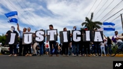 In this May 30, 2018 photo, anti-government protesters carries letters that form the Spanish word for "Justice" during a march against the government of Nicaragua President Daniel Ortega, and his wife Vice President Rosario Murillo in Managua, Nicaragua.