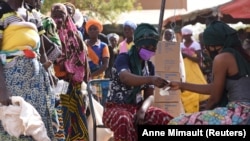 Des femmes déplacées par des attaques de milices font la queue pour recevoir l'aide alimentaire du Programme alimentaire mondial (PAM) à Pissila, au Burkina Faso, le 24 janvier 2020. 