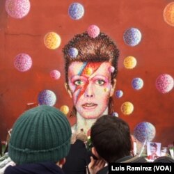 Fans gather Monday to mourn the death of David Bowie at a mural of the singer in his native London neighborhood of Brixton, Jan. 11, 2016.