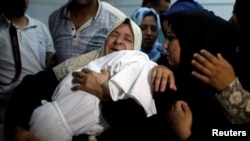 A relative mourns as she carries the body of 8-month-old Palestinian infant Laila al-Ghandour, who died after inhaling tear gas during a protest against the U.S. embassy move to Jerusalem, at the Israel-Gaza border, during her funeral in Gaza City, May 15, 2018.