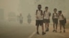 FILE - Students walk along a street as they are released from school to return home earlier due to the haze in Jambi, Indonesia's Jambi province, Sept. 29, 2015, in this picture taken by Antara Foto.