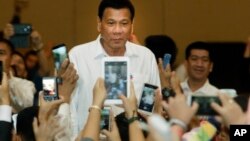 Philippine President Rodrigo Duterte, arrives a meeting with the Filipino community, in Phnom Penh, Cambodia, Tuesday, Dec. 13, 2016. Duterte on Tuesday arrived Phnom Penh on his two-day official to Cambodia. (AP Photo/Heng Sinith)