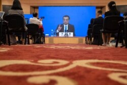Chinese Premier Li Keqiang speaks on screen during a press conference by video conferencing at the end of the National People's Congress in Beijing on May 28, 2020.