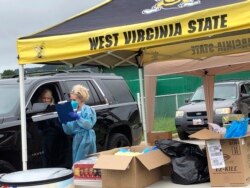 Parents and students arrive in their vehicles for health screenings and temperature checks before moving belongings into residence halls at West Virginia State University campus Friday, July 31, 2020, in Institute, W. Va. (AP Photo/John Raby)