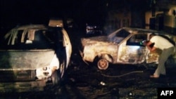 A man checks the wreckage of a car at the scene of a suicide blast at the predominantly Christian Sabon Gari neighborhood in Kano, northern Nigeria, May 18, 2014.