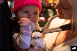 Elison Epsom gleda u svoju ćerku Akejšu koja je izabrala svoj prvi ukras za jelku.