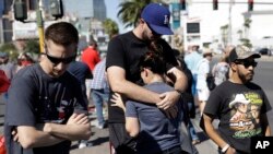 Reed Broschart, center, hugs his girlfriend Aria James on the Las Vegas Strip in the aftermath of a mass shooting at a concert in Las Vegas, Oct. 2, 2017.