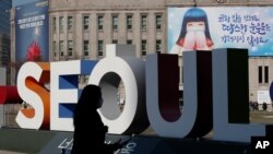 지난 21일 한국 서울 거리에서 신종 코로나바이러스 예방 마스크를 쓴 시민이 걷고 있다. 