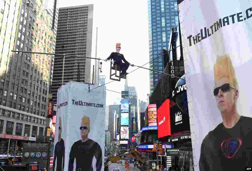 Bintang sirkus Bello Nock melintas dengan menggunakan kabel di atas Times Square di kota New York.