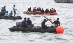 Rescuers carry debris found in the waters around the location where a Sriwijaya Air passenger jet lost contact with air traffic controllers shortly after the takeoff, in Java Sea, near Jakarta, Indonesia, Jan. 10, 2021.