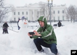 A man from Colorado takes a selfie with a snowman in front of the White House in Washington, January 2016. (AP)