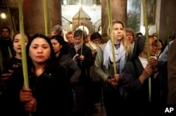 Christian pilgrims hold palm fronds during the Palm Sunday procession in the Church of the Holy Sepulcher, traditionally believed by many to be the site of the crucifixion, in Jerusalem's Old City, March 20, 2016.