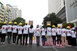 FILE - Demonstrators stand in line as they form a message with their t-shirts during a protest against the military coup in Yangon, Myanmar, February 22, 2021. REUTERS/Stringer/File Photo
