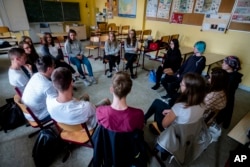 Laura Schulmann, center right, and Sophie Steiert, center left, listen to questions from students about Jewish daily life in Germany during a lesson as part of a project about religions at the Bohnstedt Gymnasium high school in Luckau, Germany, June 25, 2018.