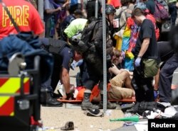 Rescue workers assist people who were injured when a car drove through a group of counter protestors at the "Unite the Right" rally Charlottesville, Virginia, Aug. 12, 2017.