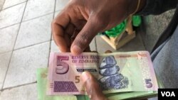 Un homme à Harare détient des obligations émises par la Banque de réserve du Zimbabwe, le 15 octobre 2018.
