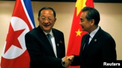 លោក​រដ្ឋមន្ត្រី​ការបរទេស​ចិន Wang Yi (រូប​ស្តាំ) ចាប់​ដៃ​ជាមួយ​នឹង​លោក​រដ្ឋមន្ត្រី​ការបរទេស​កូរ៉េ​ខាង​ជើង Ri Yong Ho មុន​កិច្ចប្រជុំ​ទ្វេ​ភាគី​របស់​ពួកគេ នៅ​ក្នុង​ក្រុង​ម៉ានីល ប្រទេស​ហ្វីលីពីន កាលពី​ថ្ងៃទី៦ ខែសីហា ឆ្នាំ២០១៧។