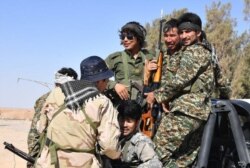 FILE - Fighters from the al-Fatemiyoun Brigade gather in Syria in this undated photo.