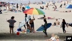 Para pengunjung di Pantai Huntington, California, di tengah pandemi virus corona, 30 April 2020. 