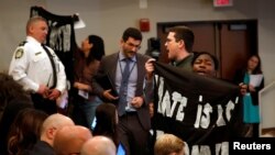 Protesters interrupt remarks by Acting Department of Homeland Security (DHS) Secretary Kevin McAleenan at the Migration Policy Institute annual Immigration Law and Policy Conference in Washington, Oct. 7, 2019.