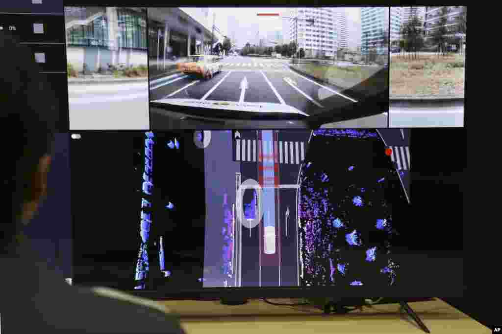 Nissan officials remotely monitor on screens the path and surroundings of the self-driving vehicle being tested on regular roads, at Nissan headquarters in Yokohama, on March 6, 2025. (AP Photo/Yuri Kageyama)