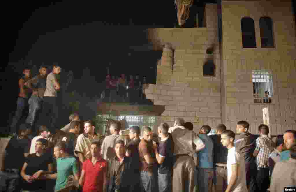 People gather following a blast at the family home in Hebron of one of the men Israel accuses of kidnapping three teenagers who were later found dead, July 1, 2014. 