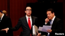 Menteri Keuangan AS Steven Mnuchin berbicara dengan seorang delegasi dalam pertemuan menteri keuangan dan gubernur bank sentral negara-negara G20 di Fukuoka, Jepang, 8 Juni 2019.
