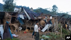 FILE - Seorang pria melihat rumah-rumah yang hancur setelah serangan udara dan artileri di kamp pengungsi Mung Lai Hkyet, di Laiza, Myanmar, 10 Oktober 2023. (AP)