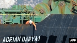 A crew member checks the new name of Iranian oil tanker Adrian Darya, formerly known as Grace 1, off the coast of Gibraltar. Gibraltar rejected a U.S. demand to seize the tanker at the center of a diplomatic dispute.
