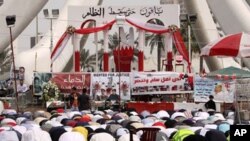 Anti-government protesters participate during midday prayers at the Pearl roundabout in Manama, Bahrain, February 25, 2011