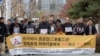 Victims of Japan's forced labor and their family members arrive at the Supreme Court in Seoul, South Korea, Nov. 29, 2018. The sign reads "Mitsubishi Heavy Industries must apologize and compensate victims."