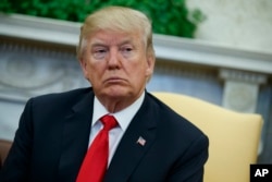 President Donald Trump listens during a meeting with North Korean defectors in the Oval Office of the White House, Feb. 2, 2018.