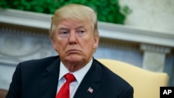 FILE - President Donald Trump listens during a meeting in the Oval Office of the White House, Feb. 2, 2018.