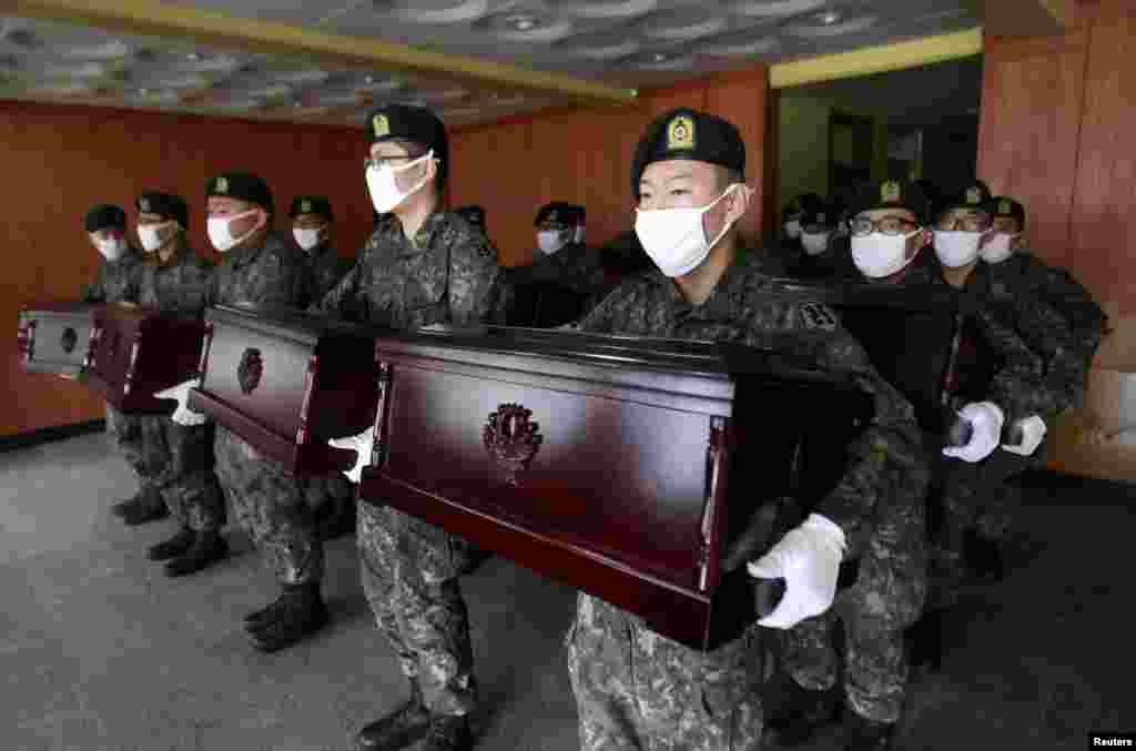 South Korean army soldiers hold caskets containing the remains of Chinese soldiers to be transported to Incheon International Airport, at the temporary columbarium in Paju. The remains of 437 Chinese soldiers killed during the 1950-53 Korean War were transferred from the temporary columbarium in South Korea to the airport to be returned to China.