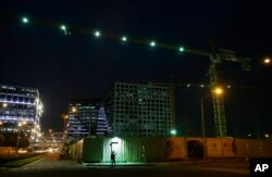 A Filipino worker checks his phone as he waits outside a construction site at a commercial area in suburban Pasay, south of Manila, Philippines, May 19, 2016. The Philippine economy grew faster than expected at 6.9 percent in the first quarter from the same period a year ago.