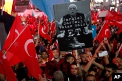 Supporters of Turkish President Recep Tayyip Erdogan wave their national flags and hold a portrait of Fethullah Gulen, a U.S.-based Muslim cleric, with Turkish words that read: "the Coup nation traitor, FETO" (Feto is the nickname of Fethullah Gulen).