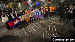 សកម្មជន​ខ្មែរអាមេរិកាំង ចូលរួម​ក្នុង​ពិធី​ដុតទៀន​នៅមុខ​ស្នាក់ការ​អង្គការ​សហ​ប្រជាជាតិ ក្នុង​ទីក្រុង New Yorkនៅ​ទិវា​សិទ្ធិ​មនុស្ស​កាលពី​ថ្ងៃទី១០ ខែធ្នូ ឆ្នាំ២០២១ ដើម្បី​ទាមទារ​ឲ្យ​ដោះលែង​អ្នកទោស​នយោបាយ។ (រូបថត​ផ្តល់​ឲ្យ​ដោយ CNRPA)