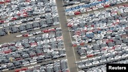 FILE - Cars for export stand in a parking area at a shipping terminal in the harbor of the northern German town of Bremerhaven, Oct. 8, 2012. 