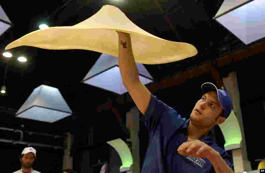 Bradley Johnson of the United States performs with his dough during the freestyle event, part of the Pizza World Championships, in Parma, northern Italy.