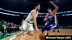 Gordon Hayward des Boston Celtics, à gauche, contre Dario Saric de Philadelphie, Boston, le 16 octobre 2018. 
