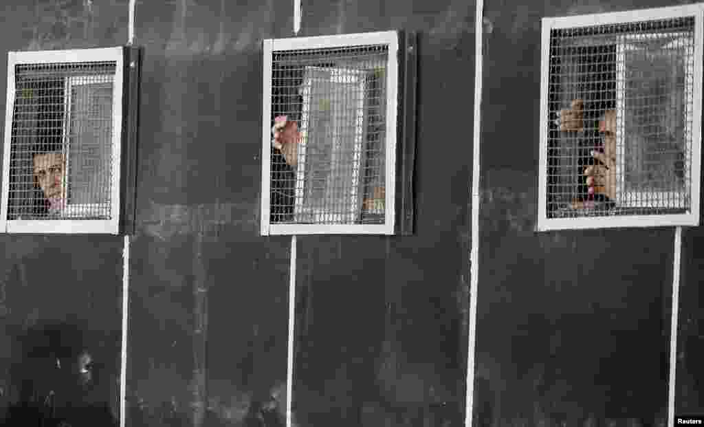 Polisi anti huru-hara memandang keluar dari jendela kendaraan mereka di depan gedung pengadilan saat demonstran menggelar aksi protes anti Presiden Mohammed Morsi dan anggota Ikhwanul Muslimin di dekat Lapangan Tahrir di Kairo.