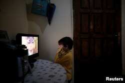 Panagiotis Argyros watches cartoons in his house at the suburb of Keratsini in Athens, Greece, March 28, 2017.